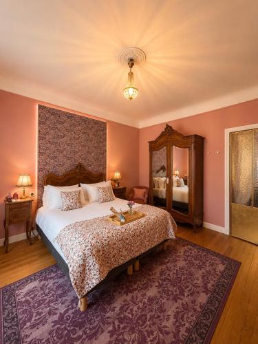 a bedroom with a large bed and a mirror at La Maison au toit vert in Espalion