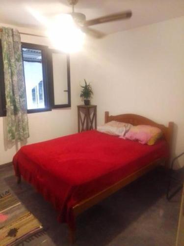 a bedroom with a bed with a red blanket at villa des Filaos et du lagon 0693-70'59'79 in Saint-Leu