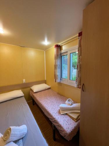 a small room with two beds and a window at Seaside Garden Galaxidi in Galaxidi