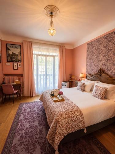 a bedroom with a large bed with a table on it at La Maison au toit vert in Espalion