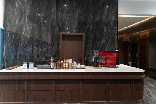 a counter in a hotel room with a red chair at Champs Elysees Hotel & Suites in Phnom Penh