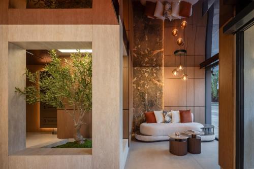 a living room with a couch and a tree at PLATINUM hotel & spa in Sarajevo