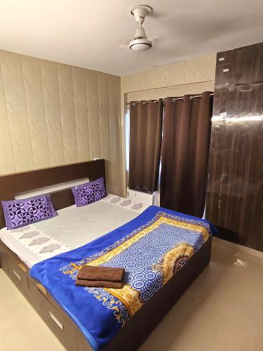 a bedroom with a large bed with purple pillows at 2BHK 65TV,FullyAC,family,Unmarried Couple,WFO Friendly peacefull place in Noida