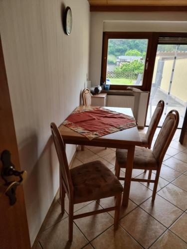 a dining room table with two chairs and a window at Tinas Ferienwohnung in Kröv