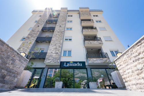 a tall white building with a sign that reads la lamont at Lamadu Residence in Sutomore