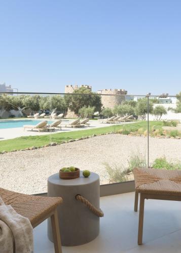 a living room with a table and a view of a pool at Fata Morgana Studios & Apartments in Frangokastello