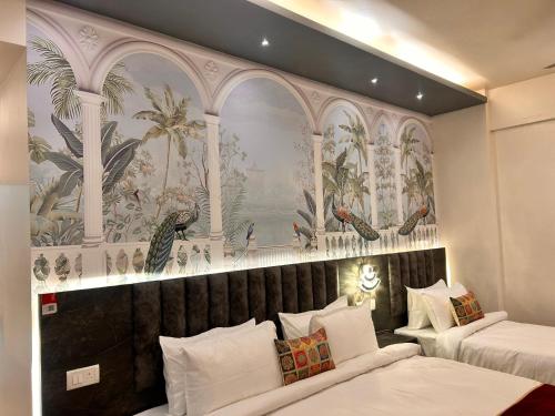 two beds in a hotel room with a wall mural at The Origin Suites opposite Hyatt Dlf my pad Lucknow in Lucknow