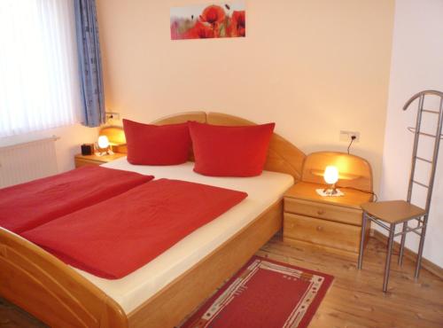 ein Schlafzimmer mit einem großen Bett mit roten Kissen in der Unterkunft Fewo D am Kurpark in Willingen