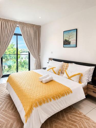 a bedroom with a large bed and a window at EMBASSY - Sky Suites in Accra