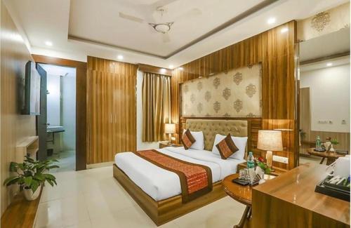 a hotel room with a bed and a desk at Hotel Almati Inn Near IGI Delhi Airport - With Free Airport Pickup in New Delhi