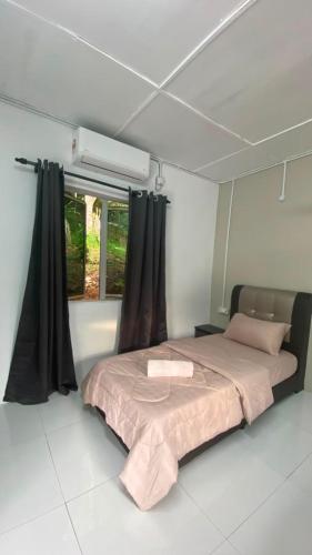 a bedroom with a large bed with black curtains at Durian Chalet in Kuala Tahan