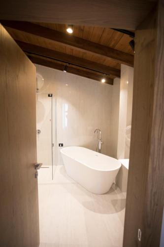 a bathroom with a large white tub and a shower at Agroturizem Prelude in (( Barç ))