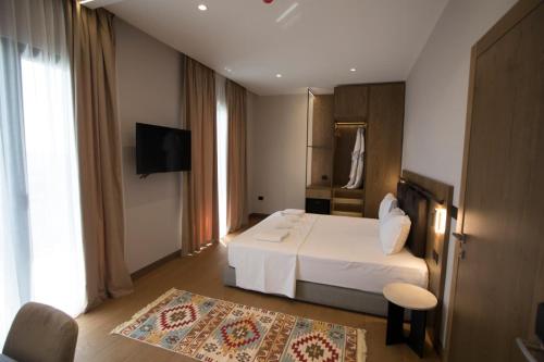 a hotel room with a bed and a television at Agroturizem Prelude in (( Barç ))