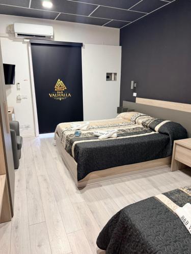 two beds in a room with a sign on the wall at B&B Valhalla in Paola
