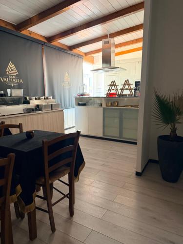 a kitchen with a table and a dining room at B&B Valhalla in Paola