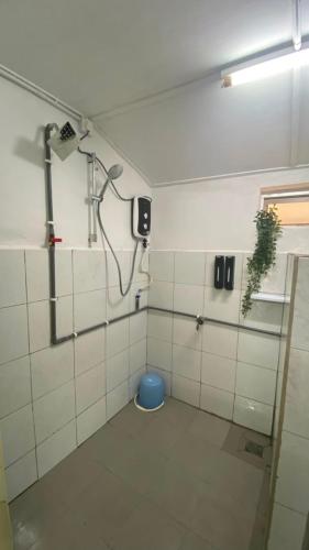 a bathroom with a shower and a blue bucket at Durian Chalet in Kuala Tahan