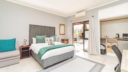 a bedroom with a large bed and a kitchen at Bosveld In Die Stad 2 Guesthouse in Alberton