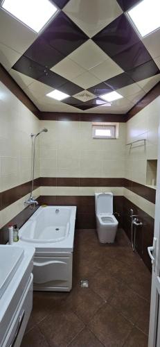 a bathroom with a bath tub and a toilet at Casa Villa in Baku