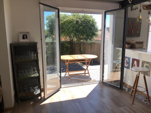 a room with a table and a sliding glass door at Villa Maude & Jean in Lacanau-Océan