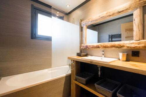 a bathroom with a sink and a tub and a mirror at Cozy chaleett on SLOPES in Crest-Voland