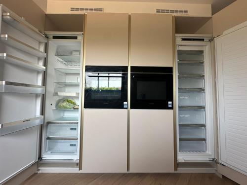 a walk in closet with white doors and shelves at Villa ALDAKETA in Urrugne