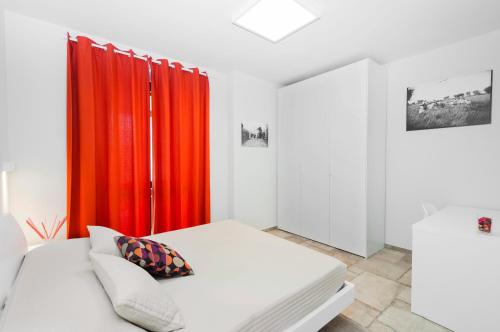 a room with a bed and red curtains at Moresco Agriturismo in Moresco