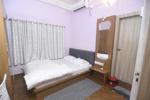 a small bedroom with a bed and a mirror at Nahor Residency in Guwahati