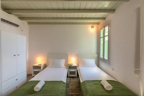 two beds in a small room with two lamps at Serifos View in Serifos Chora