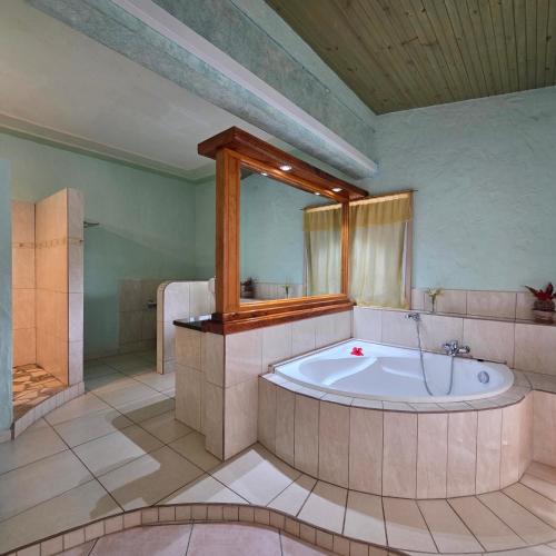 a large bathroom with a tub and a shower at La Diguoise in La Digue