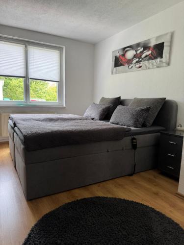 a bedroom with a large bed and two windows at Silkes FeWo in Sollstedt