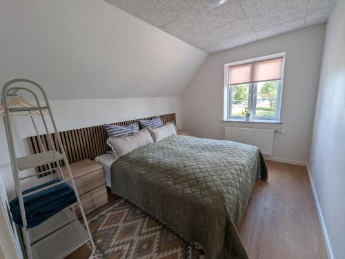 a bedroom with a bed and a ladder and a window at Kølkær B&B in Kølkær