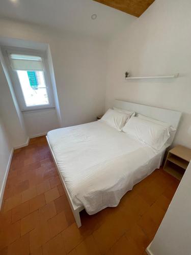 a white bed in a room with a window at SH Suite OLMO AC e Wi-Fi in Manziana