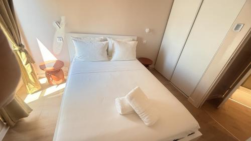 a white bed with two towels on it in a room at Azur Stay Nice in Nice