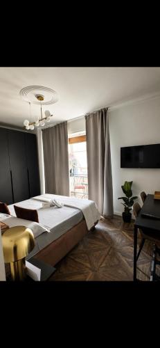 a bedroom with a large bed and a tv at BEDBLUESKY-Sparklingsuite nel centro di Dolceacqua in Dolceacqua