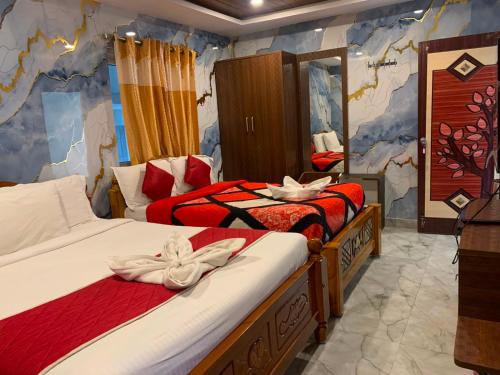 a bedroom with two beds with red sheets at Hotel Hill Edge in Kodaikānāl