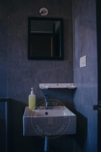a bathroom sink with a mirror and a soap dispenser at Breezy Classy Villa Mahabalipuram in Kelambākkam