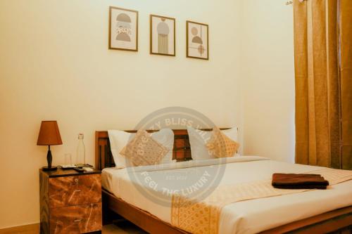 a bedroom with a bed and a table with a lamp at Breezy Classy Villa Mahabalipuram in Kelambākkam