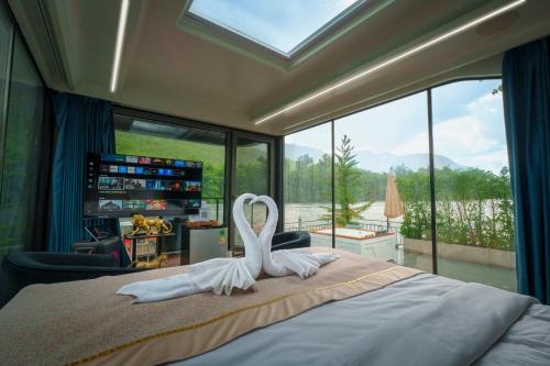 a bedroom with a bed with two swans on it at แพในฝัน รีสอร์ท in Ban Tha Thong Mon