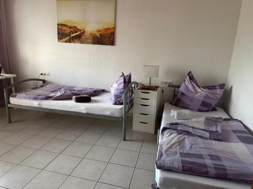 a bedroom with two beds and a dresser and a bed sidx sidx sidx sidx at Sonnenblick Kleiberweg in Mosbach