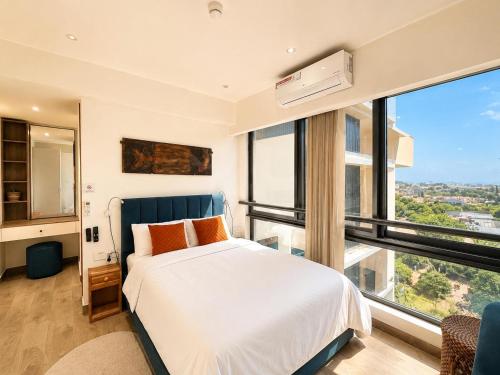 a bedroom with a bed and a large window at SOLARIS APARTMENT-Sky Suites in Accra