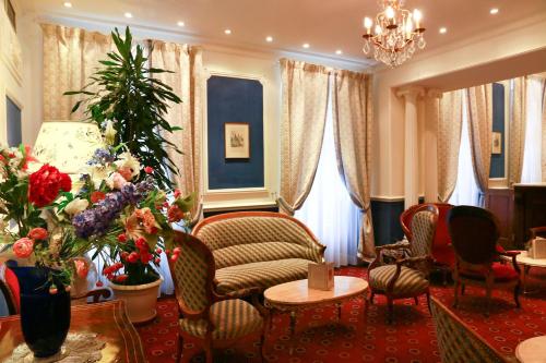 a living room with a couch and chairs and a christmas tree at Hôtel d'Etigny in Luchon
