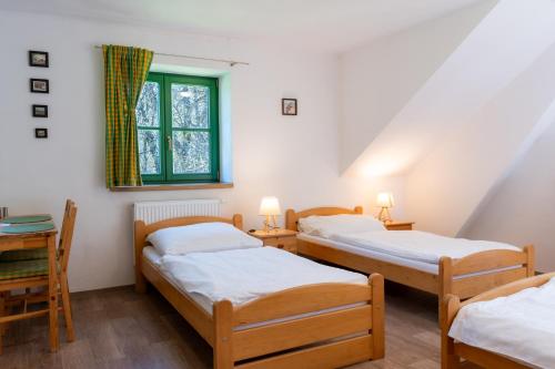a room with three beds and a window at Chata Rozhlas in Železná Ruda