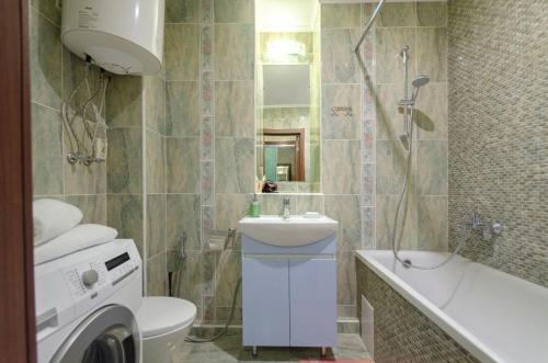 a bathroom with a sink and a washing machine at Панорамний Краєвид на Озеро Позняки Жк Лебединий in Kyiv