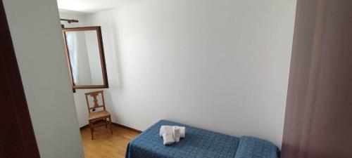 a room with a blue bed and a mirror at RAMERAHouse in Mareno di Piave