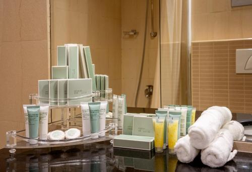 a pile of towels and products on a table in a bathroom at Imperial Suites Hotel in Doha
