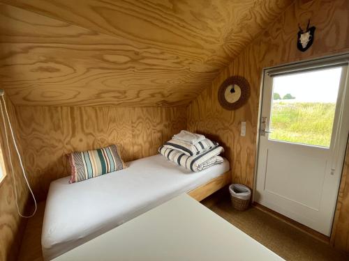 a bed in a small room with a window at Skansely in Sønderborg