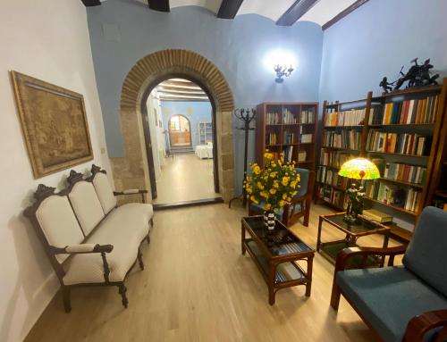 a living room with a couch and chairs and bookshelves at Garden Suites Xativa Casa Rural in Xàtiva