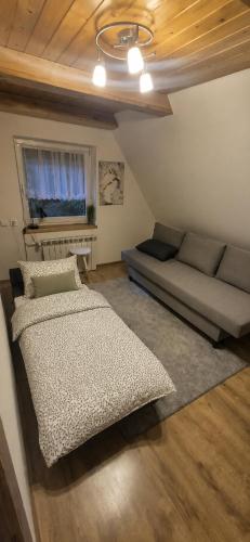 a living room with a bed and a couch at Leśna Przygoda ,,Balia w cenie" in Harbutowice