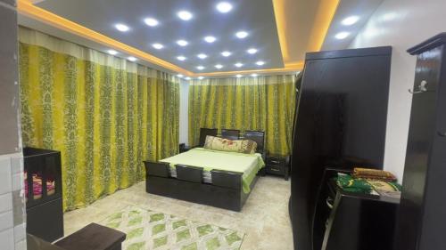 ein Schlafzimmer mit einem Bett in einem Zimmer mit grünen Vorhängen in der Unterkunft Jerash Villa For Rental in Gerasa