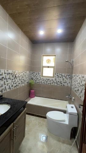 ein Badezimmer mit Toilette und Badewanne in der Unterkunft Jerash Villa For Rental in Gerasa